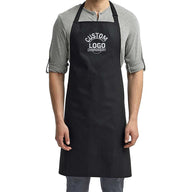 a man wearing a black apron and grey shirt