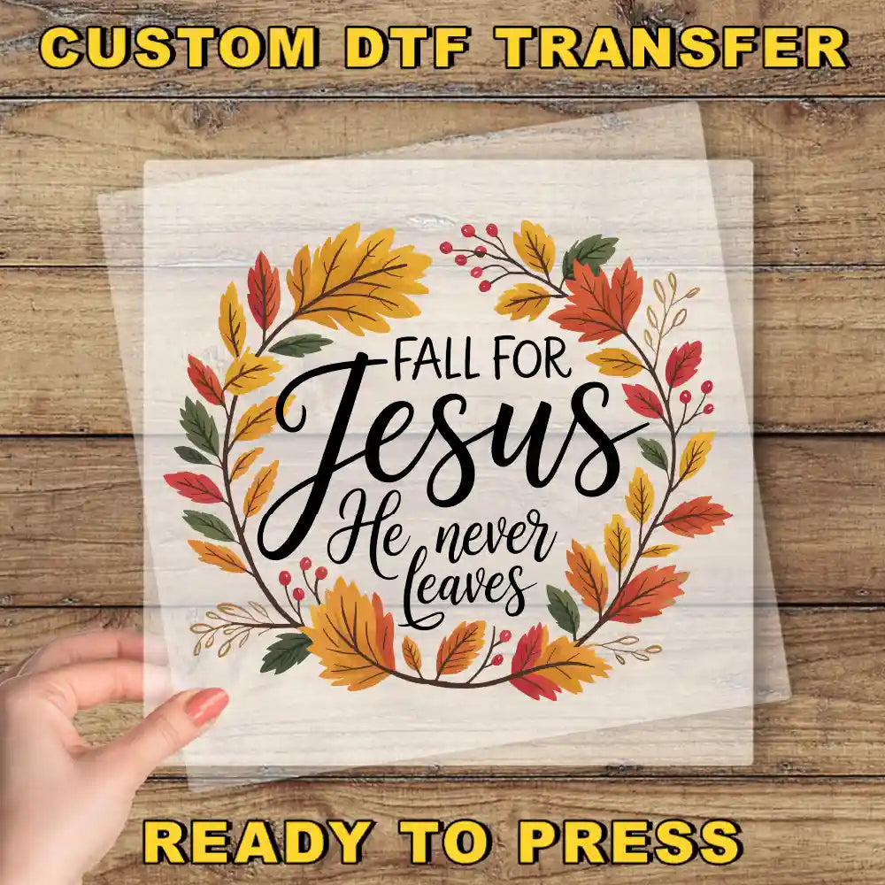a hand holding a transparent sheet with a hand-drawn wreath design and text that reads "Fall for Jesus He never leaves".