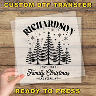 The image is a promotional image for a custom DTF transfer service. It features a hand holding a clear sheet with a black and white illustration of a Christmas tree design. The text on the sheet reads "RICHARDSON Family Christmas Las Vegas, NV" and "CUSTOM DTF TRANSFER".