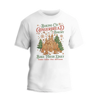 A white t-shirt with a graphic design featuring a gingerbread house and text advertising a bakery.