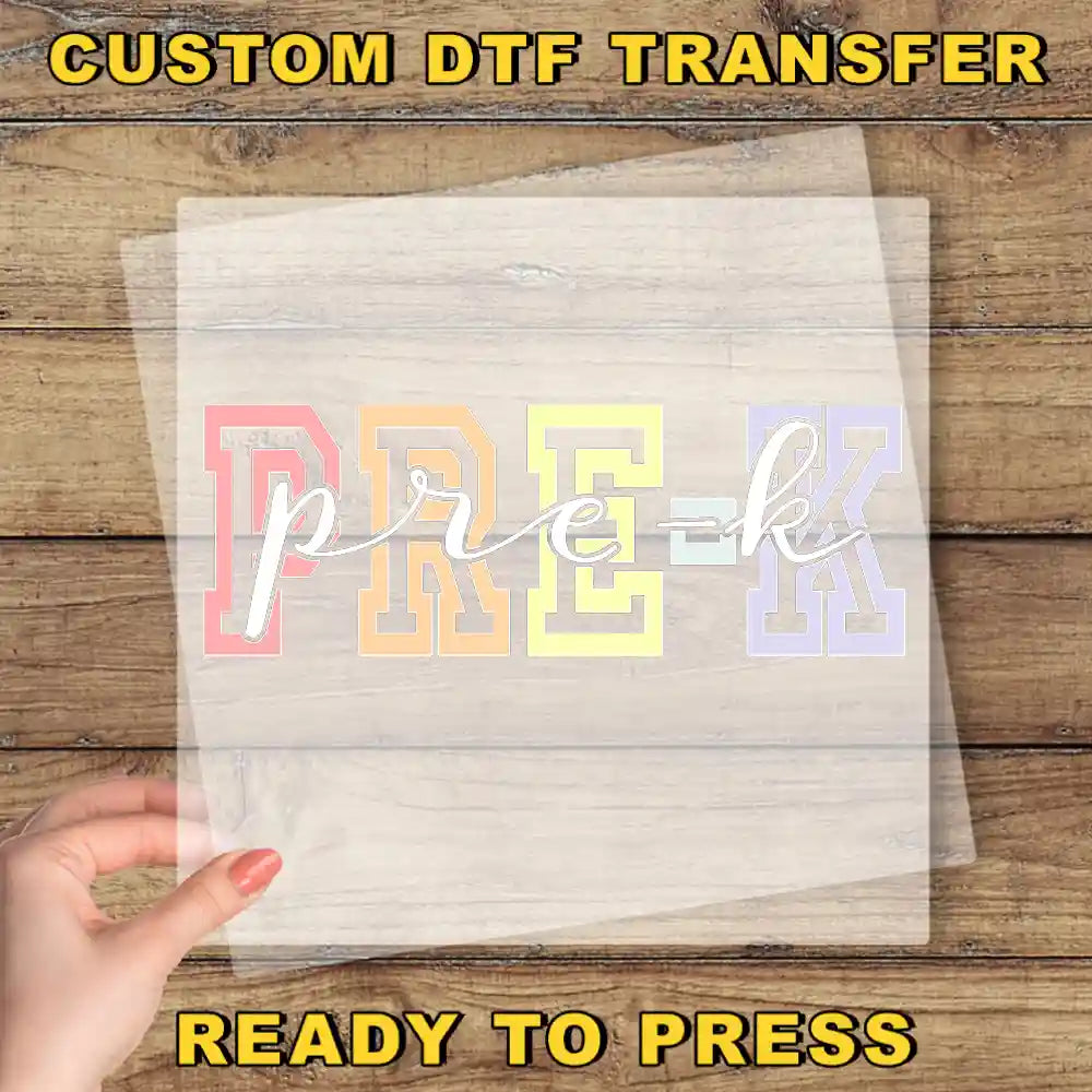 The image is a promotional image for a custom DTF (Digital Transfer Factory) transfer service. It features a hand holding a clear sheet with the word "PREK" printed on it, along with the text "CUSTOM DTF TRANSFER" and "READY TO PRESS" at the bottom.