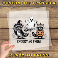 A hand is holding a clear sheet with a Halloween-themed illustration of a raccoon, a ghost, and a jack-o-lantern.