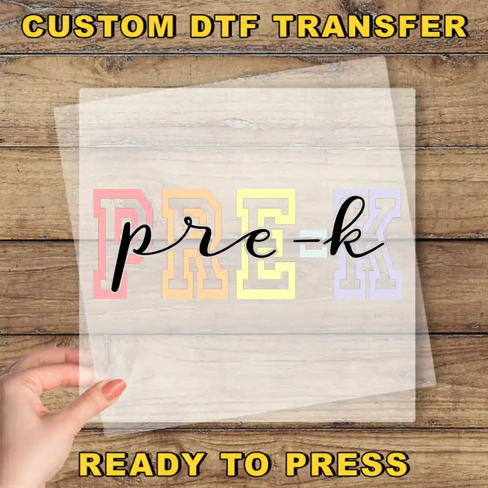 a hand holding a transparent sheet with the word "PREK" written on it, placed on a wooden surface.