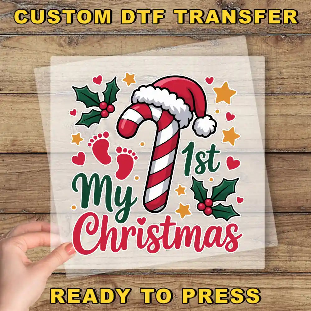 The image is a Christmas-themed graphic with a hand holding a transparent sheet that displays the text "My 1st Christmas" surrounded by festive elements such as a candy cane, holly leaves, and stars.