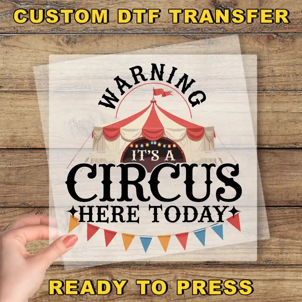 a person holding up a sign with a circus tent in the background