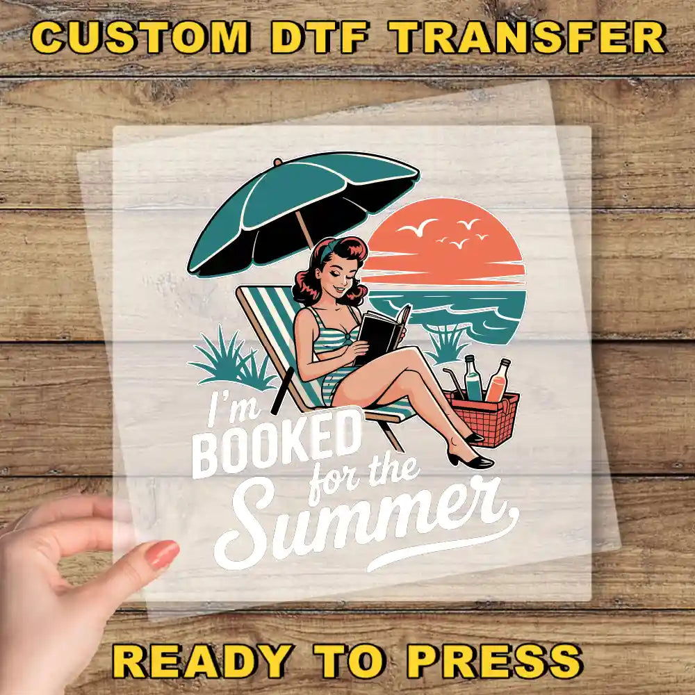 A hand holding a transparent sheet with a vintage-style illustration of a woman reading a book under an umbrella on a beach.