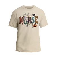 A beige t-shirt with the word "NURSE" written in a creative and colorful font, surrounded by Halloween-themed elements such as a spider web, bats, a pumpkin, and a stethoscope.