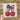 a hand holding a piece of paper with a bow and two cherries on it