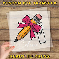 a hand holding a transparent sheet with a pencil and a pink ribbon, with the name "Celine" written below it.