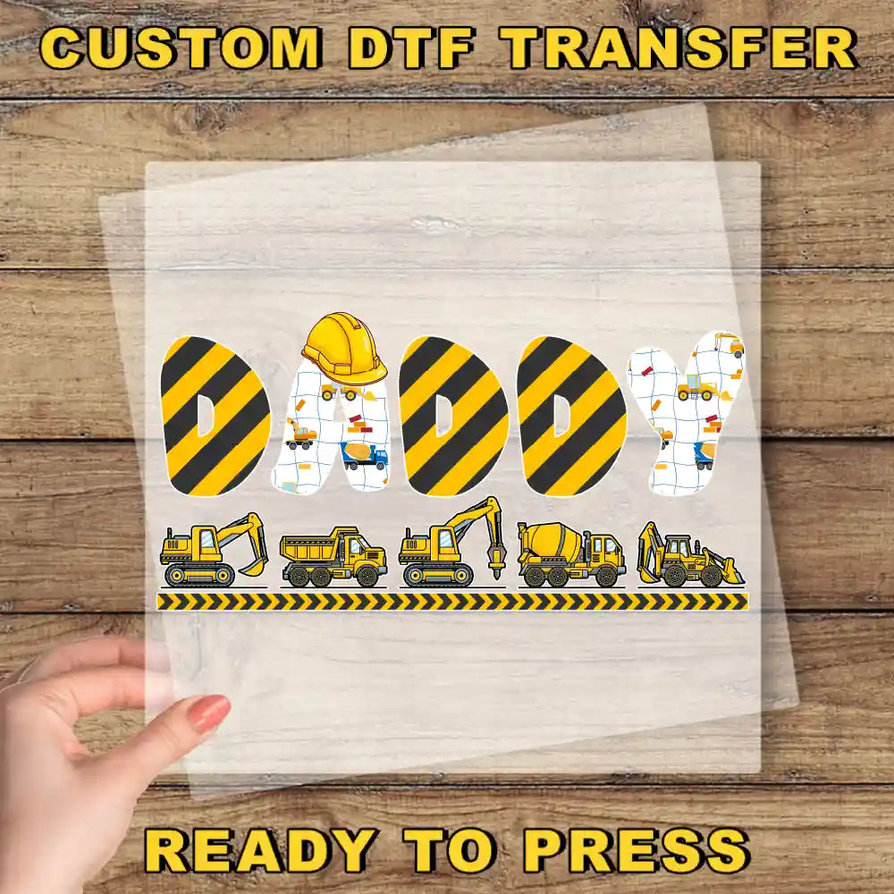 a hand holding a piece of paper with construction vehicles on it