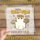 a hand holding a paper with a picture of a ghost on it
