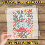 a person holding up a paper with the words praying mama raising warriors on it