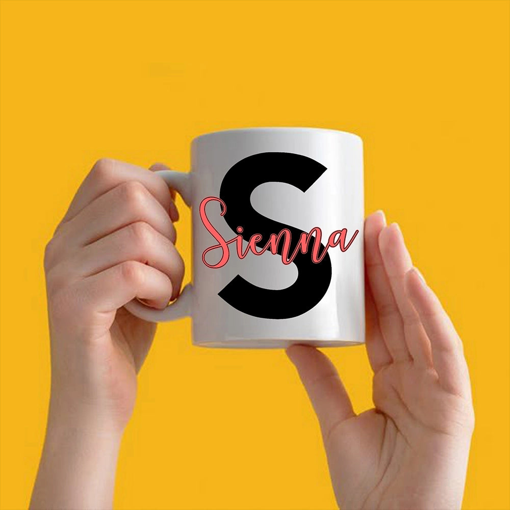 a person holding a coffee mug with the letter s on it