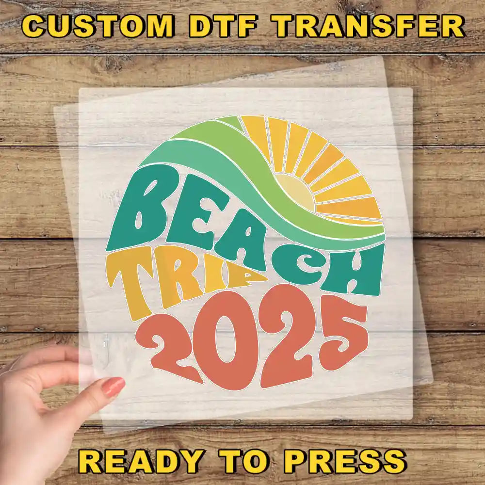 a hand holding a piece of paper with a colorful, stylized text design that says "BEACH TRIP 2025".