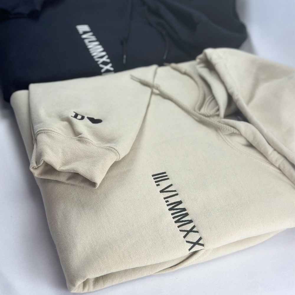 a couple of sweatshirts sitting on top of a bed