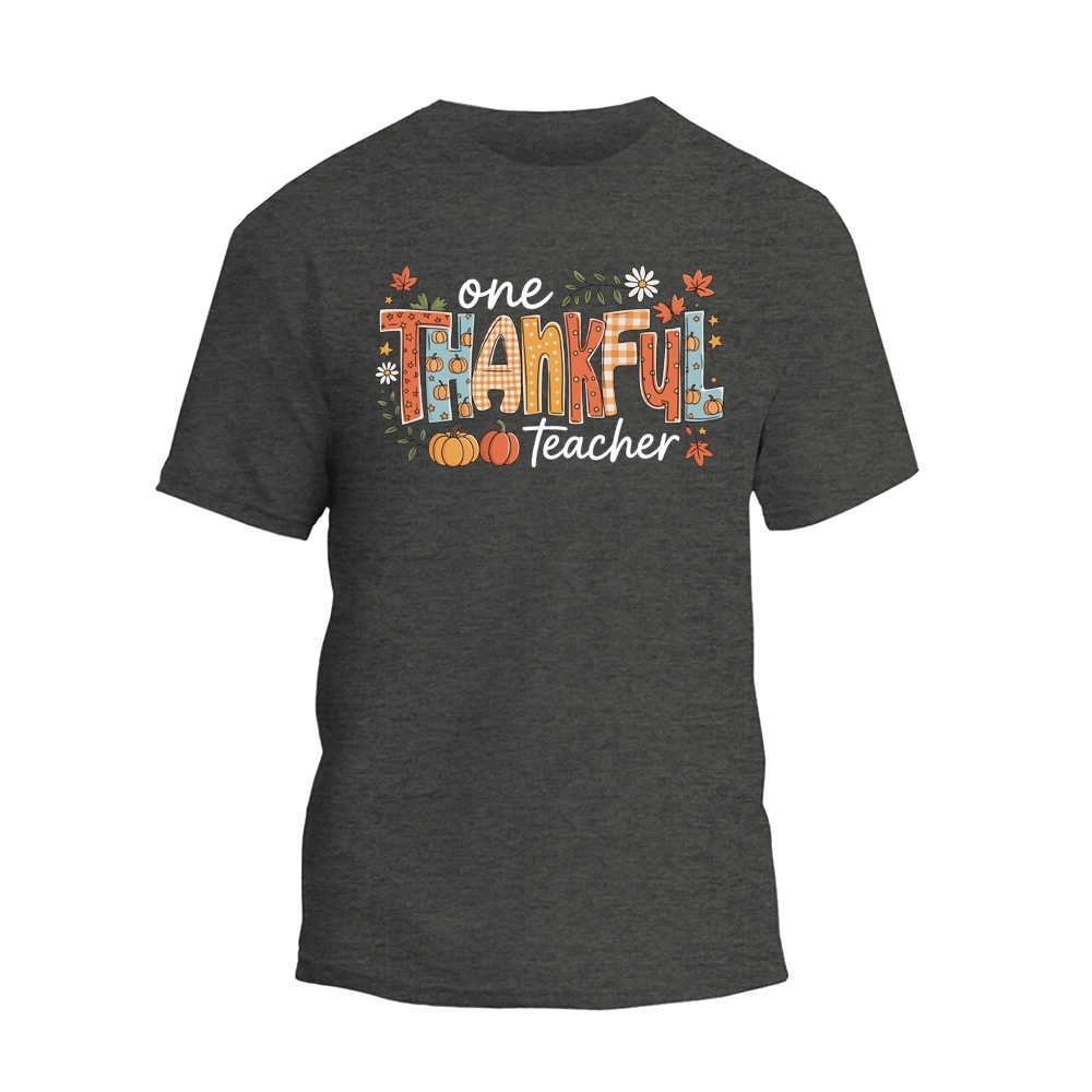 A gray t-shirt with a graphic design featuring the text "One Thankful Teacher" surrounded by autumn-themed elements such as leaves, pumpkins, and flowers.