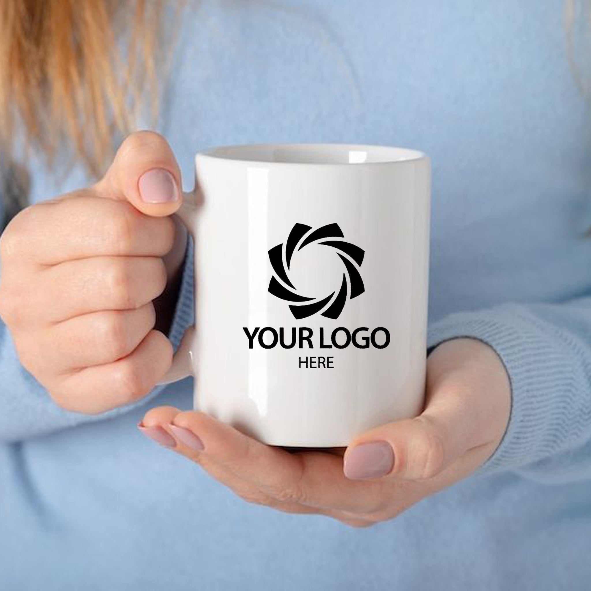 a woman holding a coffee mug with a logo on it