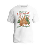 A white t-shirt with a graphic design featuring a gingerbread house and text advertising a bakery.