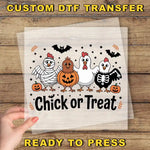 A hand is holding a clear sheet with a Halloween-themed illustration of chickens and a pumpkin, along with the text "Chick or Treat".