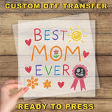 a person holding a piece of paper with the words best mom ever on it