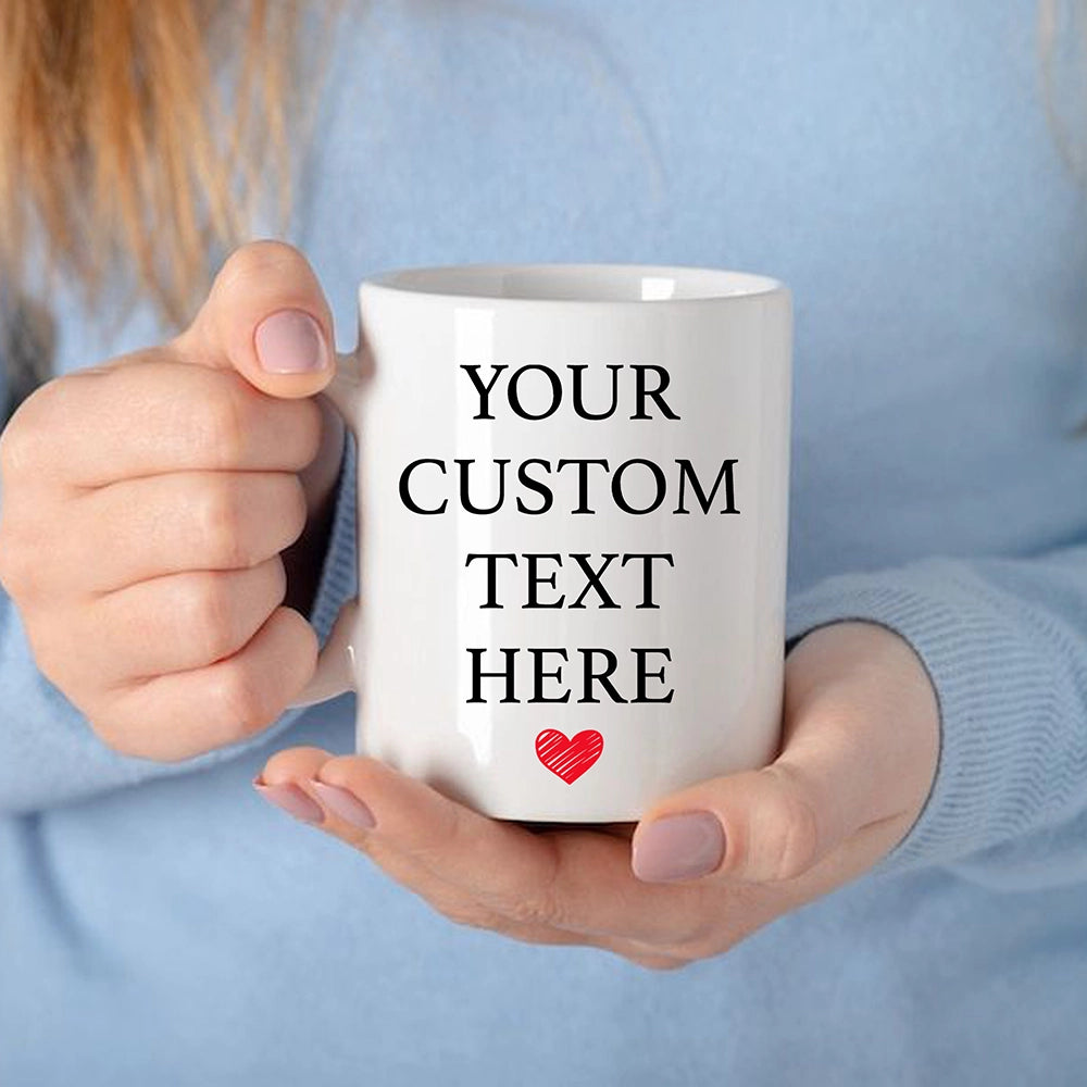 a woman holding a white coffee mug with a red heart