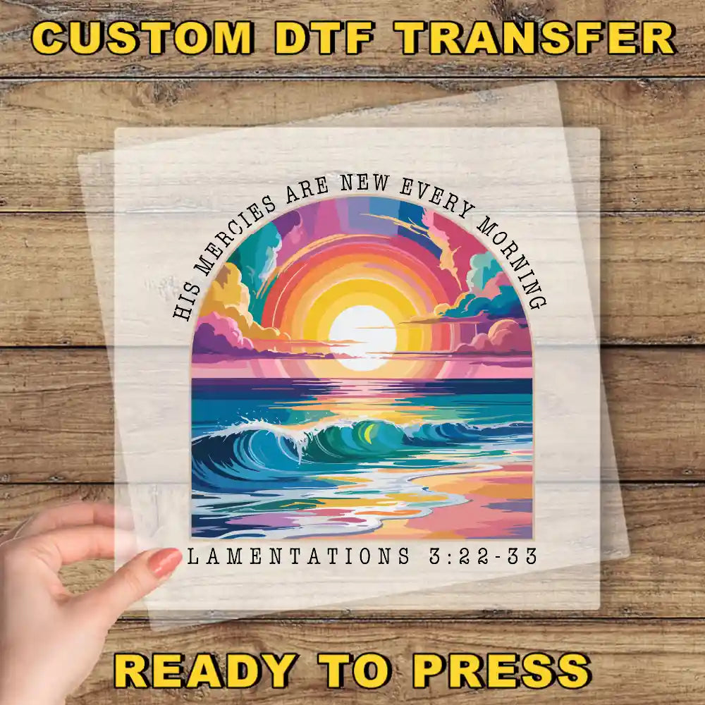 The image is a hand holding a transparent sheet with a colorful illustration of a sunrise over a body of water. The text on the sheet reads "His Mercies are new every morning" and "Lamentations 3:22-33".