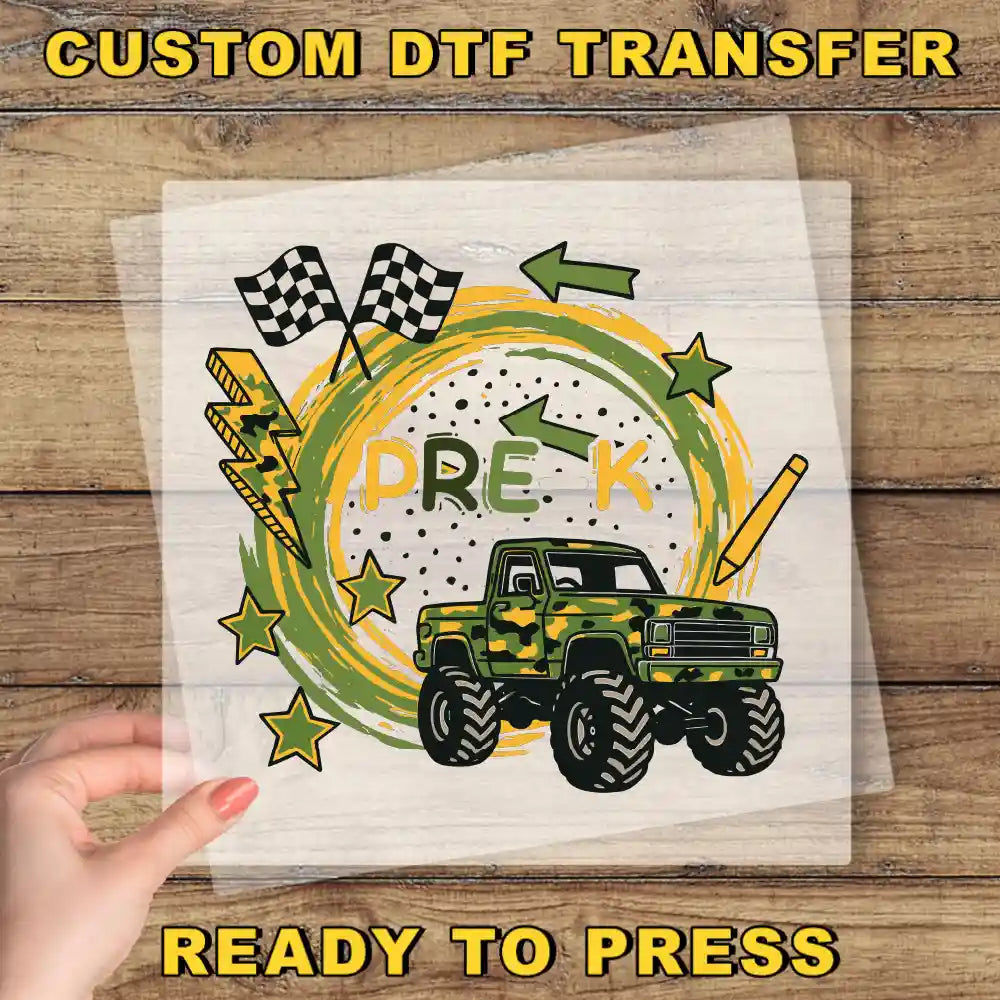a hand holding a piece of paper with a custom DTF transfer design on it. The design includes a truck, checkered flags, lightning bolts, stars, and the word "PREK" written on it.