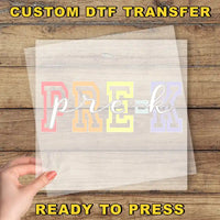 The image is a promotional image for a custom DTF (Digital Transfer Factory) transfer service. It features a hand holding a clear sheet with the word "PREK" printed on it, along with the text "CUSTOM DTF TRANSFER" and "READY TO PRESS" at the bottom.