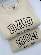 a pair of t - shirts with the words dad and mom printed on them