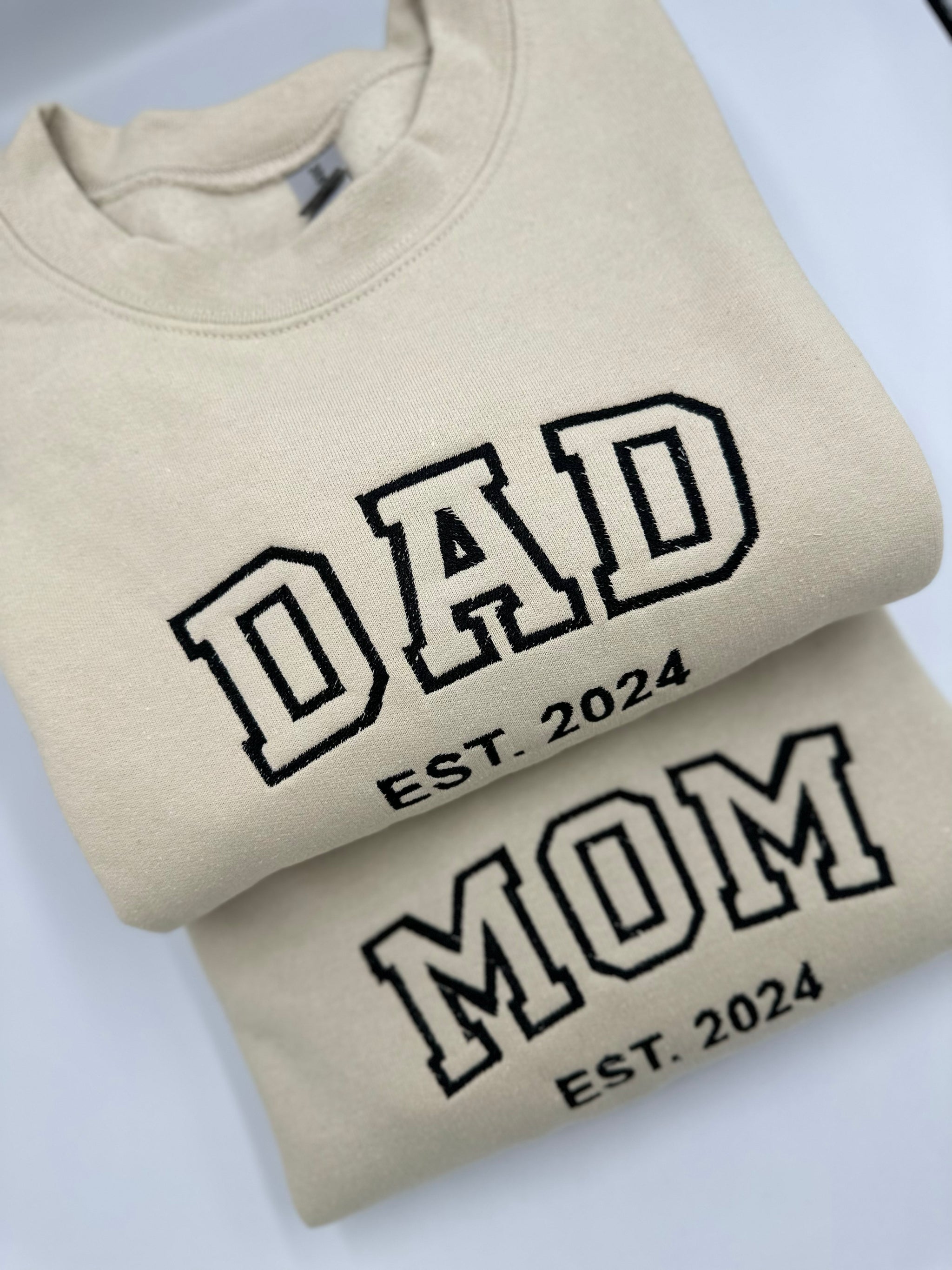 a pair of t - shirts with the words dad and mom printed on them