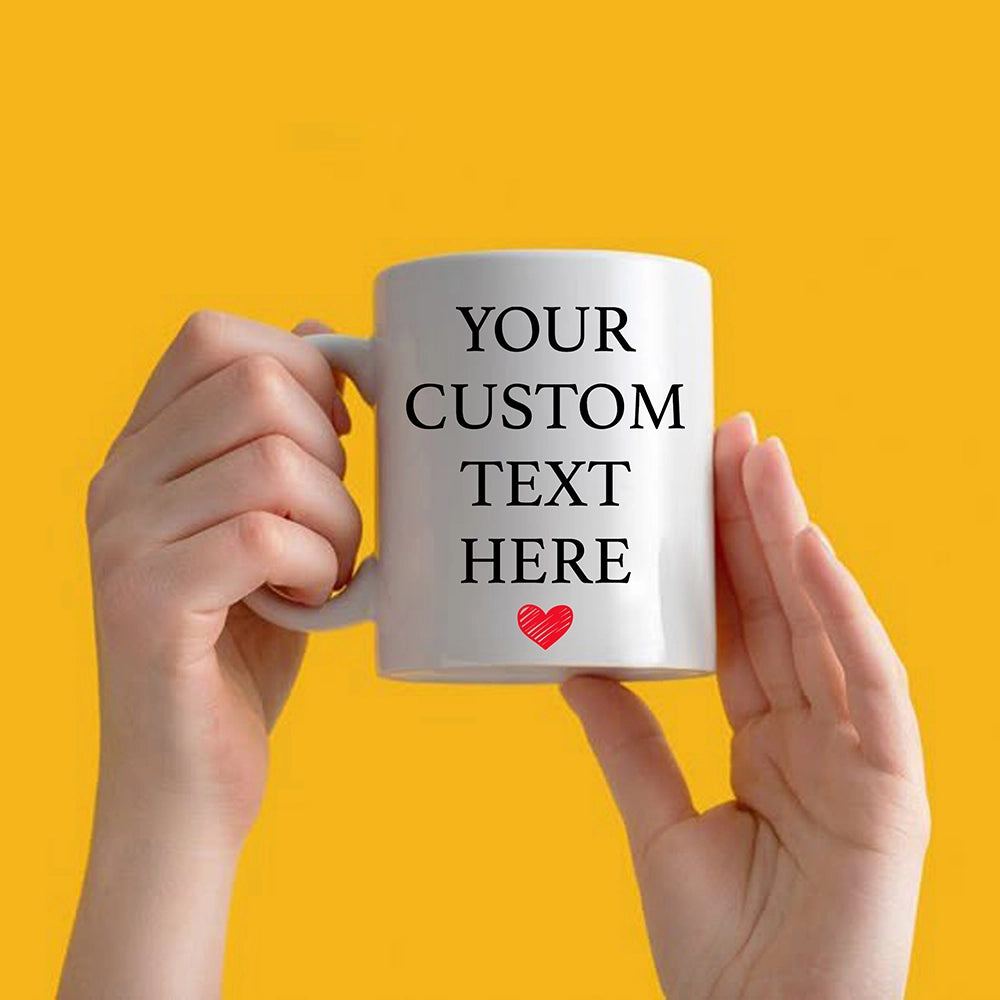 a person holding a coffee mug with a heart on it