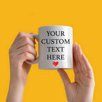 a person holding a coffee mug with a heart on it