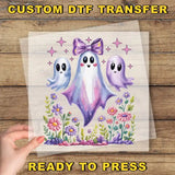 a hand holding a transparent sheet with a colorful illustration of three ghostly figures surrounded by flowers and plants.