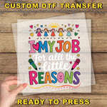 The image is a hand holding a clear sheet with a colorful and playful design featuring children and text.