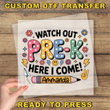 The image is a hand holding a sheet of paper with a colorful and playful design featuring text and illustrations related to pre-k education.