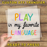 a hand holding a piece of paper that says play in my favorite language