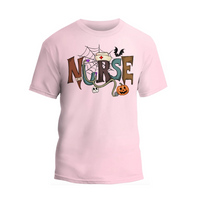 A pink t-shirt with the word "NURSE" written in a creative and colorful design, featuring a spider web, bats, a pumpkin, and other Halloween-themed elements.