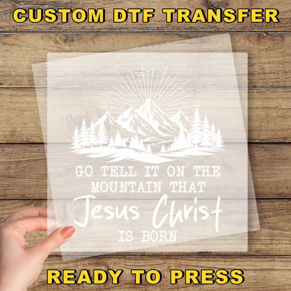 a hand holding a paper with a picture of mountains and trees on it