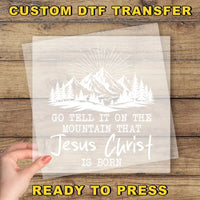 a hand holding a paper with a picture of mountains and trees on it