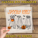 a hand holding a paper with a picture of three dogs in halloween costumes