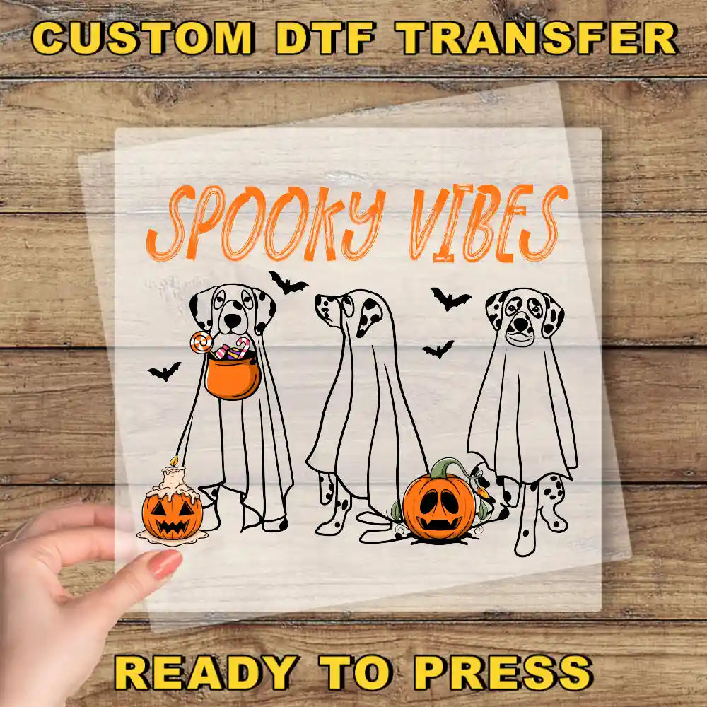 a hand holding a paper with a picture of three dogs in halloween costumes
