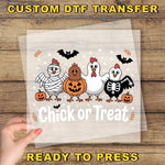 A hand is holding a clear sheet with a Halloween-themed illustration of a group of cartoon chickens, including a skeleton chicken, a pumpkin, and bats. The text "Chick or Treat" is displayed below the illustration.
