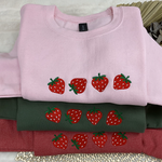a pile of different colored shirts with strawberries on them