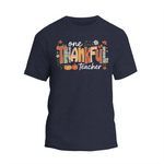A dark blue t-shirt with a colorful graphic design that says "One Thankful Teacher" in a stylized font.