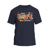 A dark blue t-shirt with a colorful graphic design that says "One Thankful Teacher" in a stylized font.