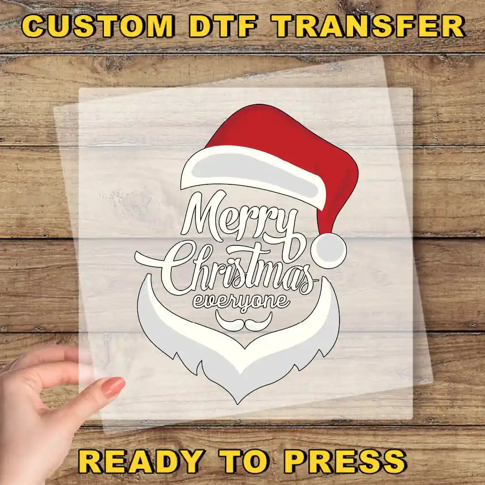 a hand holding a transparent sheet with a stylized Santa Claus design and the text "Merry Christmas everyone" printed on it.