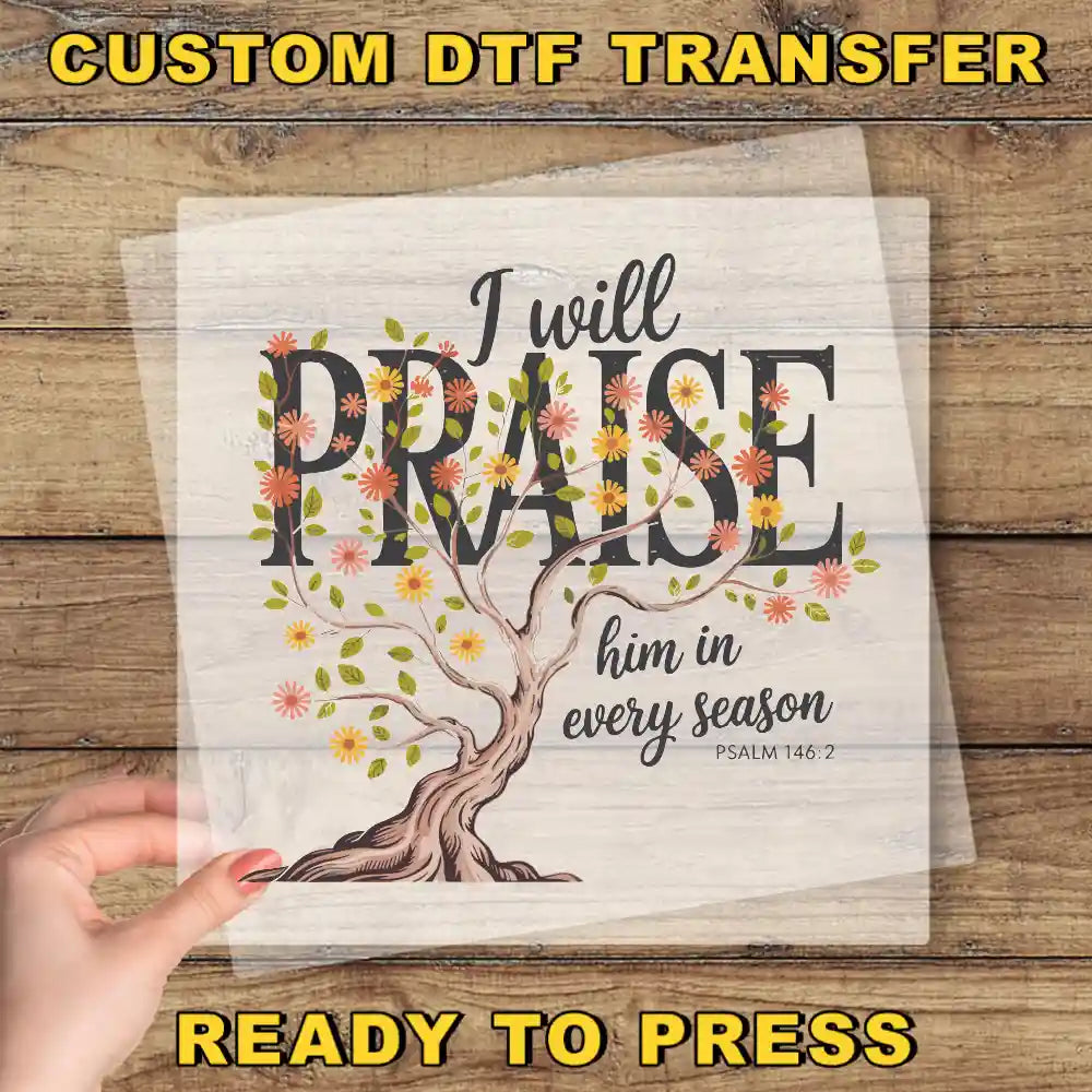 a hand holding a transparent sheet with a tree design and text, along with a wooden background.