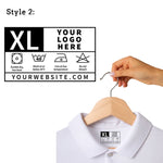 Hand holding a hanger with a white shirt and a customizable care label on a white background Custom DTF Shirt Label
