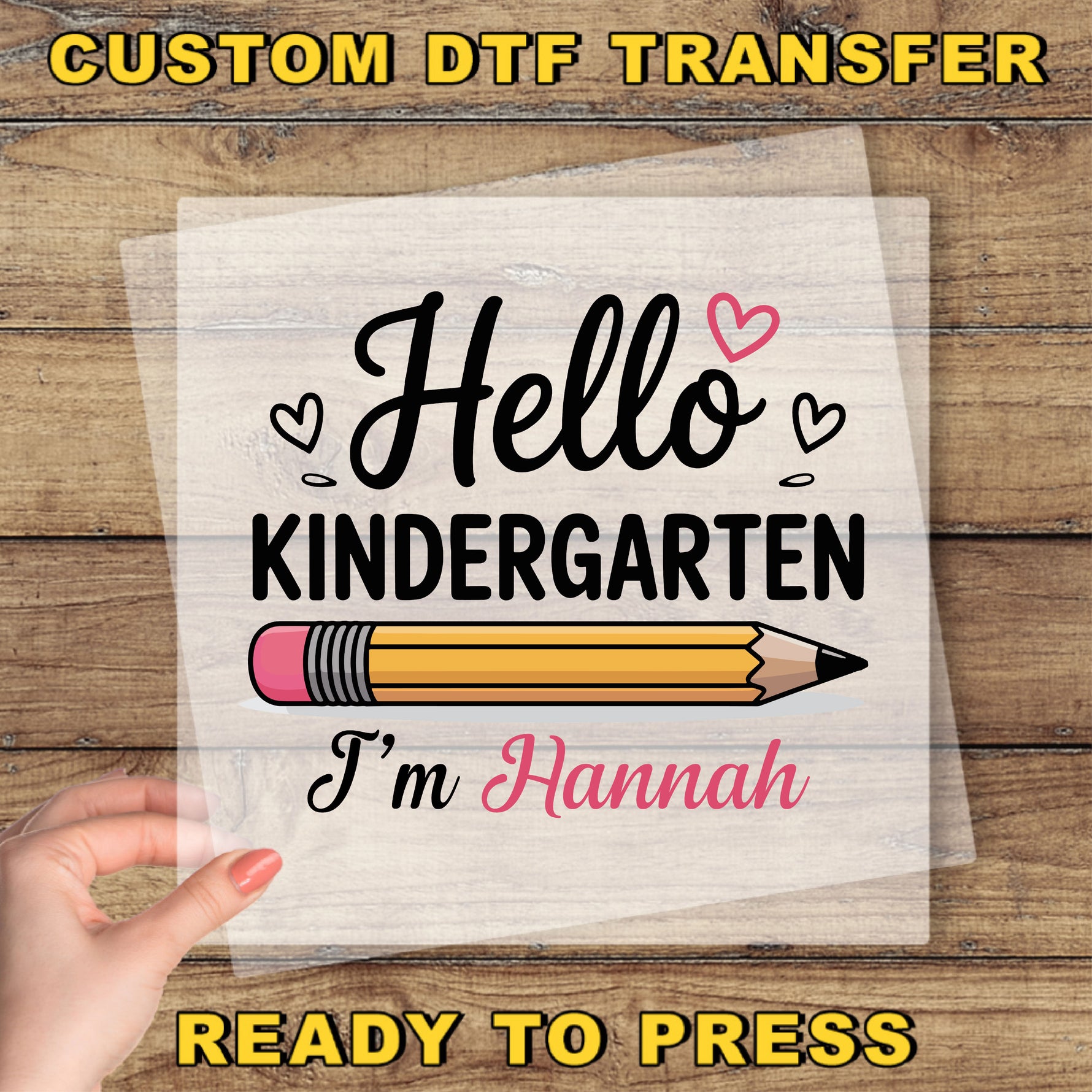 A hand holding a piece of paper with a hand-drawn pencil and the text "Hello Kindergarten I'm Hannah" printed on it.