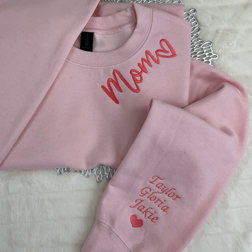 a pair of pink sweatshirts sitting on top of a bed